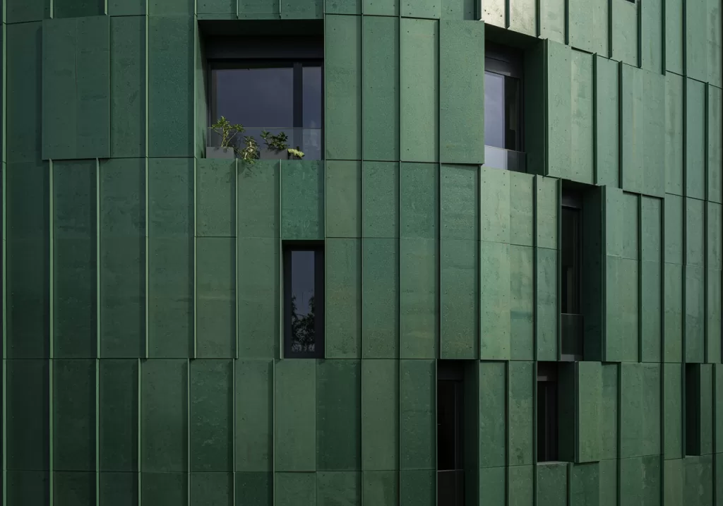 Bâtiment contemporain éco-responsable avec façade métallique en acier vert bas carbone, illustrant l’architecture durable et l’innovation environnementale.